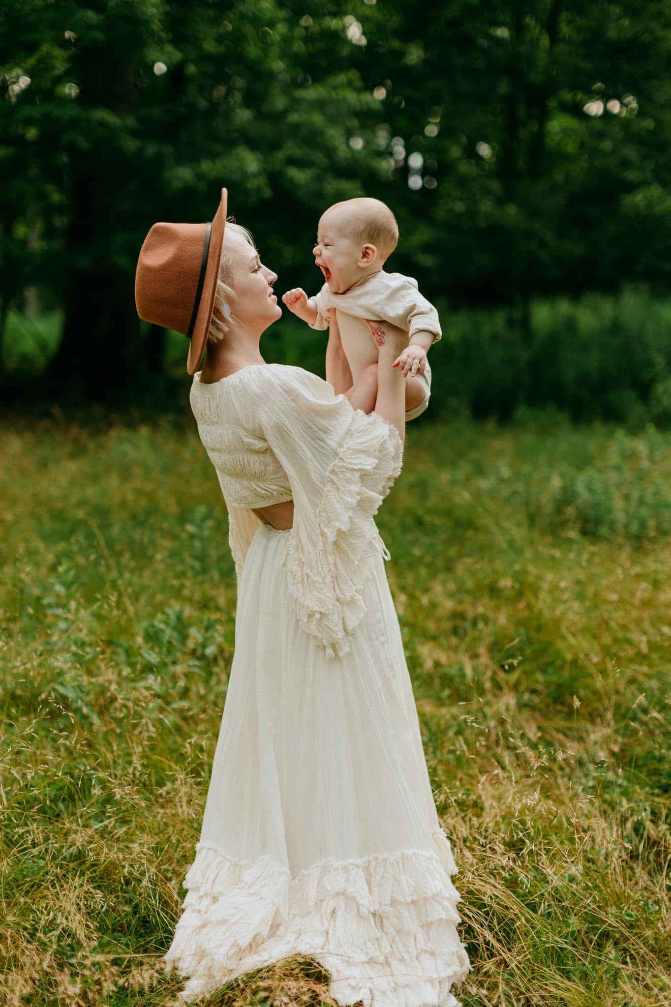 Mady laughing with her son outdoors, forest in the background
