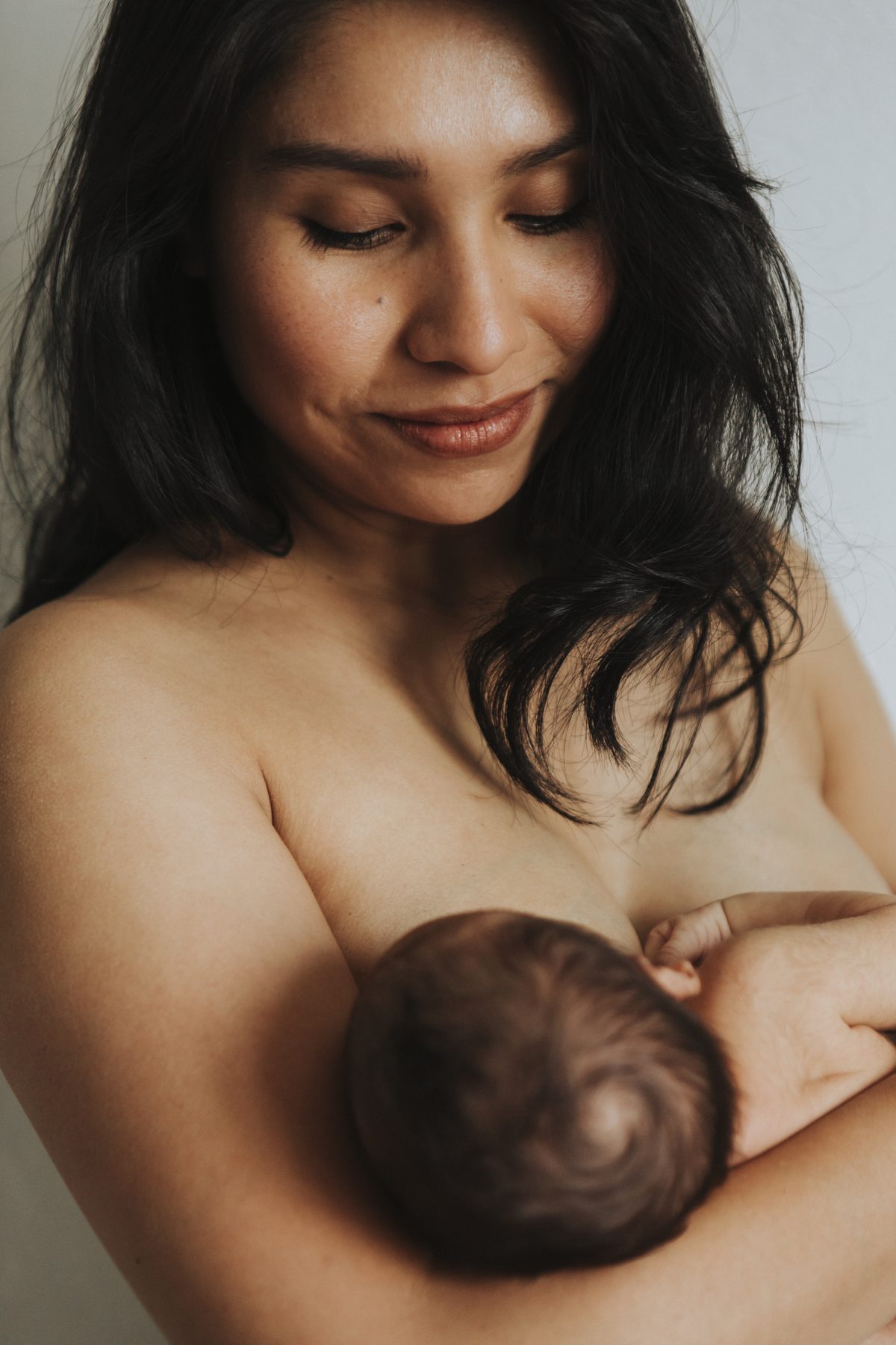 A mother feeding her infant in natural light